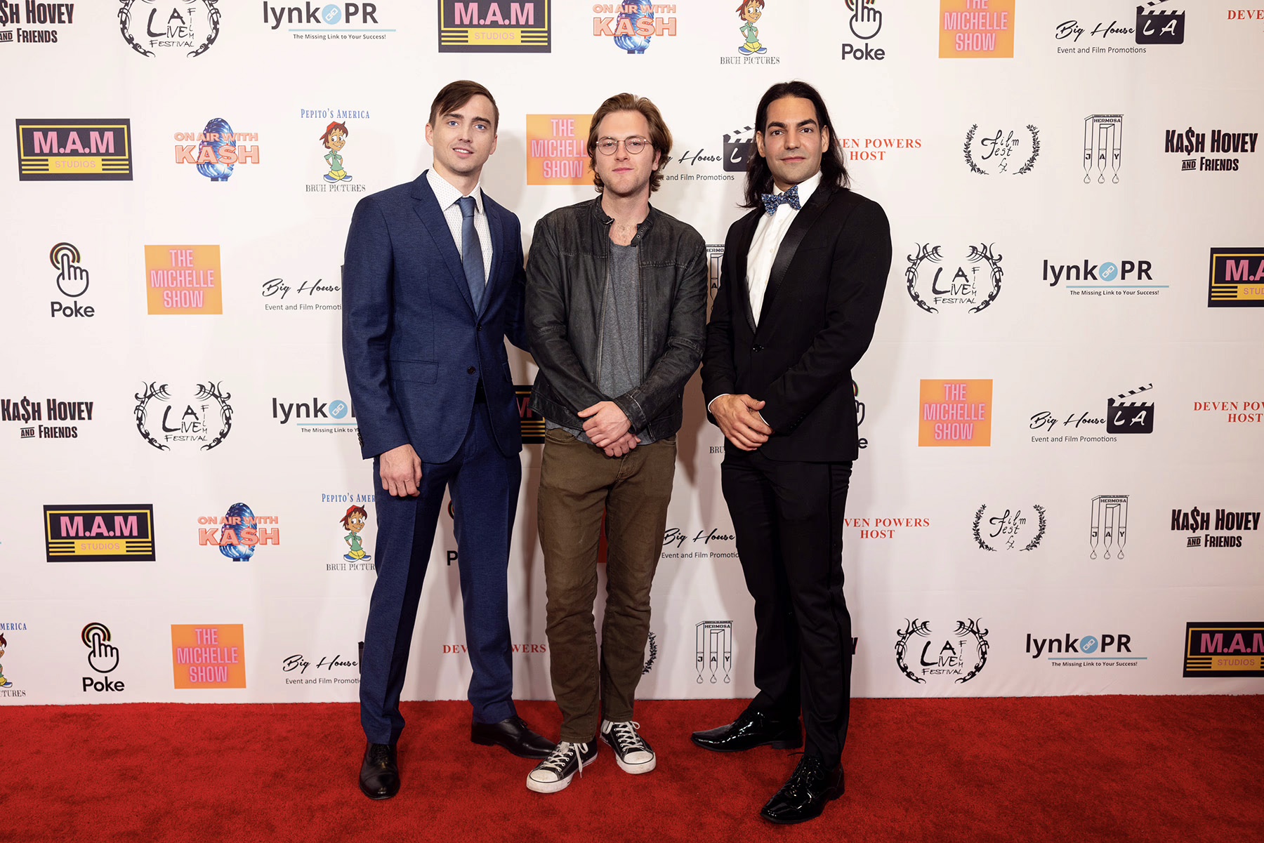 Artem Shestakov, Quinn Halleck and David Runyon posing on a red carpet, dressed in formal attire at Los Angeles film festival.