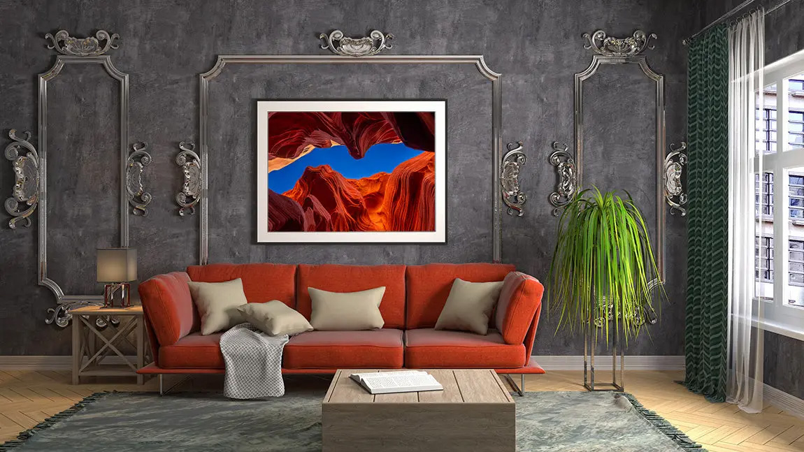 Elegant living room with a bold red sofa, a large framed landscape artwork by Artem Shestakov on the wall, and decorative molding, blending classic and modern styles.