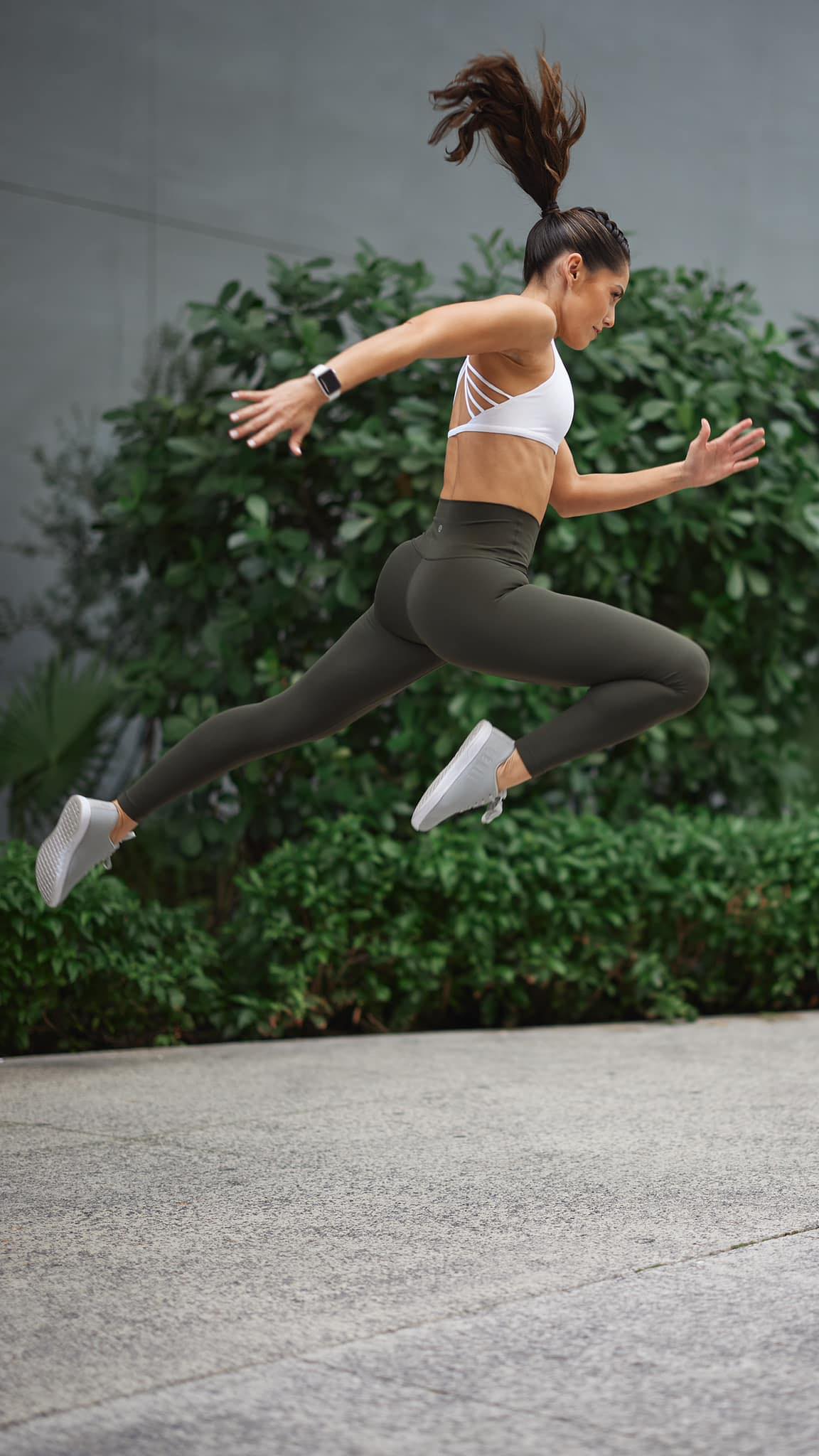 Valerie Senior mid-leap, during a run, displaying athleticism and motion in an outdoor urban setting.